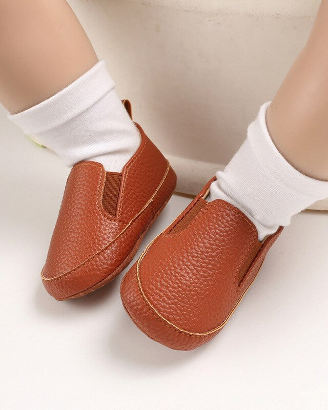 Mocasines de bebé de cuero coñac llevados con calcetines blancos Imagen