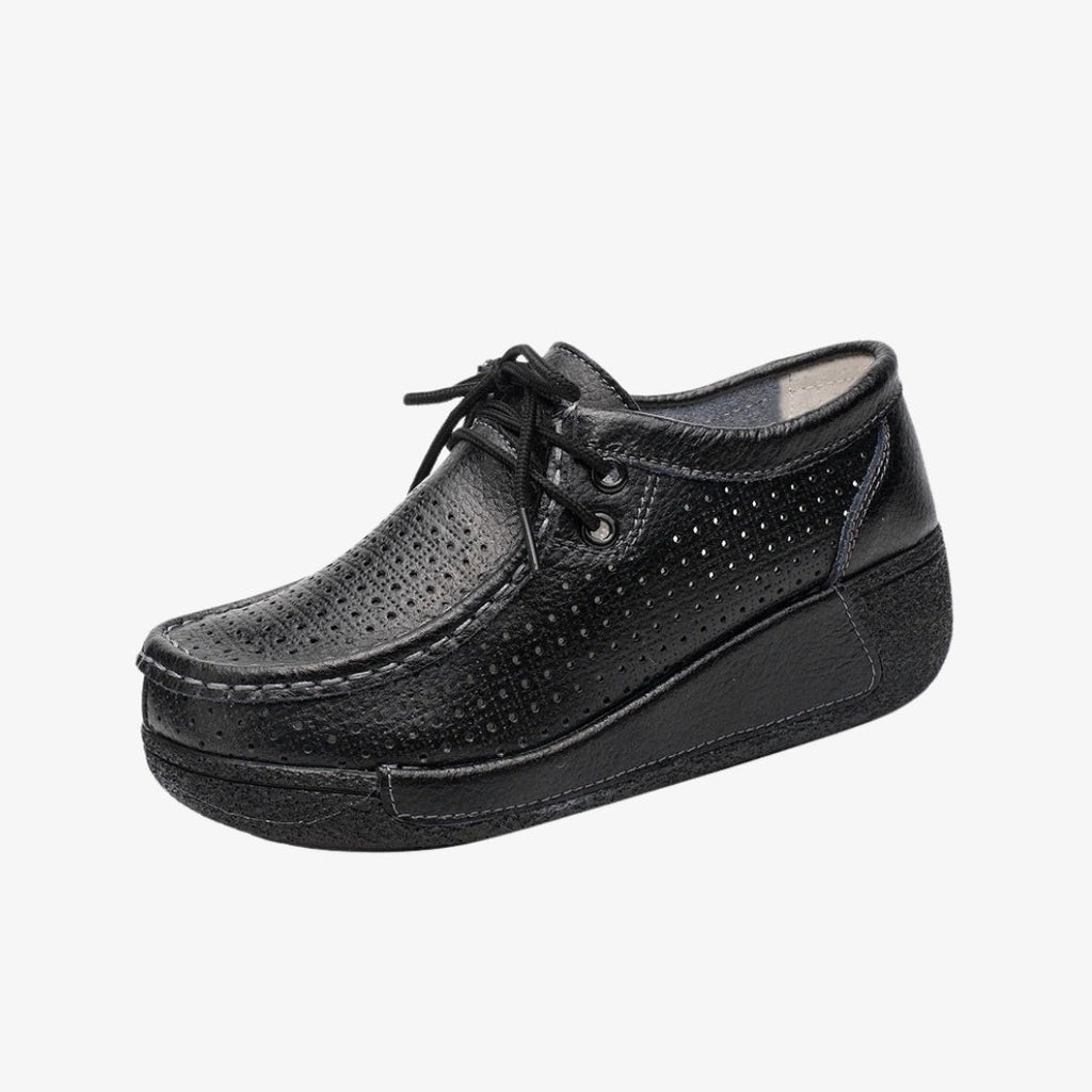 Mocasines de piel negra para mujer, con diseño perforado para una mejor aireación. Con cordones para un ajuste preciso, estos zapatos elegantes llevan suelas de cuña negras que ofrecen buena sujeción y una comodidad óptima durante todo el día.