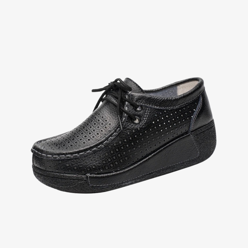 Mocasines de piel negra para mujer, con diseño perforado para una mejor aireación. Con cordones para un ajuste preciso, estos zapatos elegantes llevan suelas de cuña negras que ofrecen buena sujeción y una comodidad óptima durante todo el día.