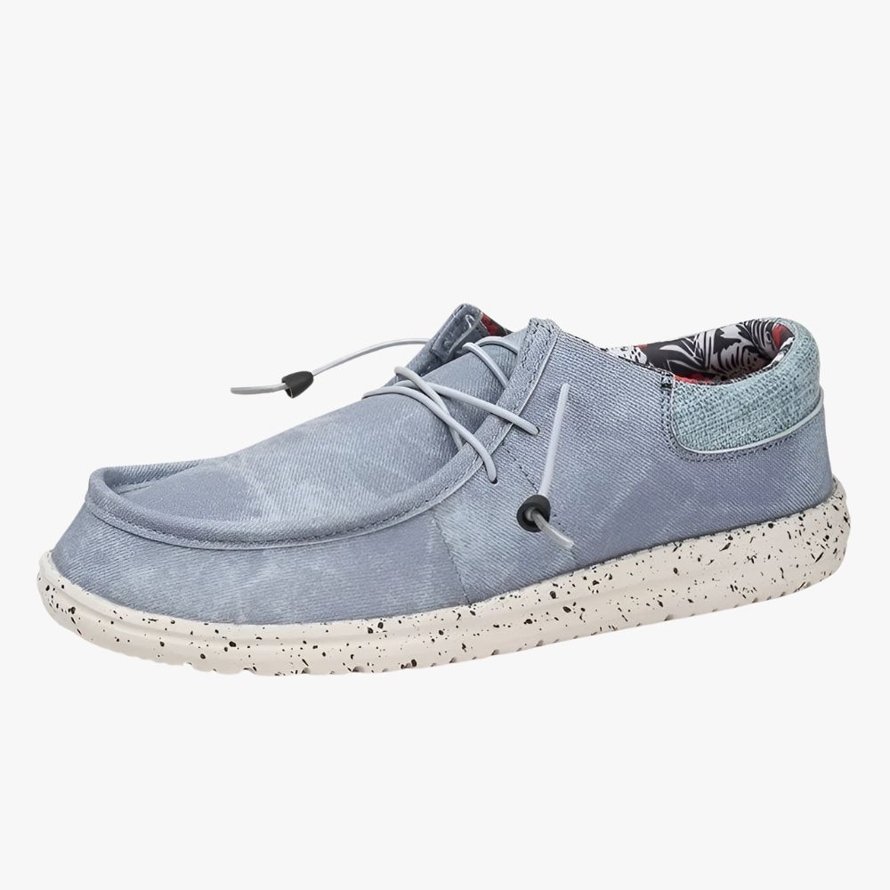 Mocasines de tela azul con suelas blancas. El forro interior es de tela con estampado de flores.