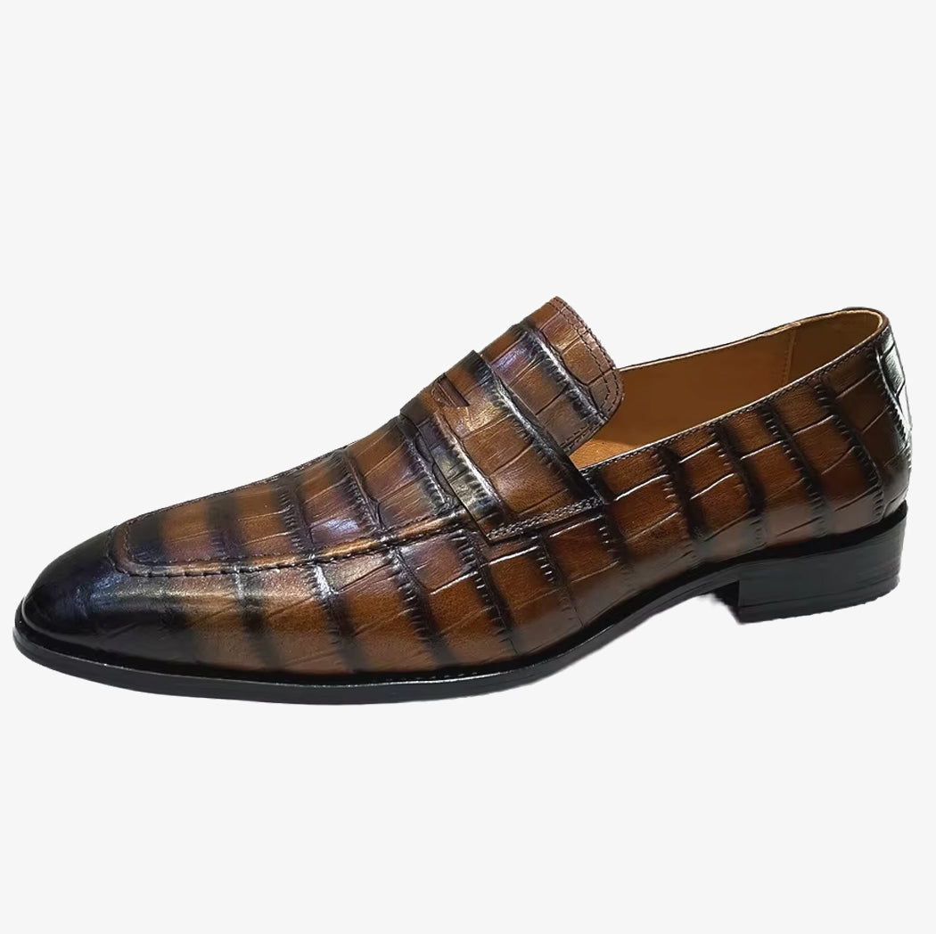 Un mocasín italiano de cuero con efecto cocodrilo para hombre sobre un fondo blanco uniforme