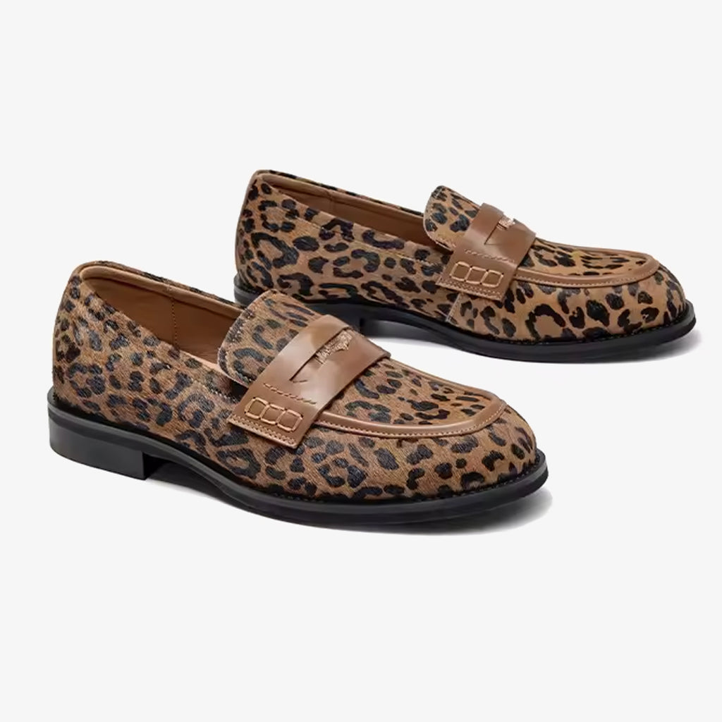 Par de mocasines de mujer en piel de leopardo con correa sobre el empeine sobre fondo blanco