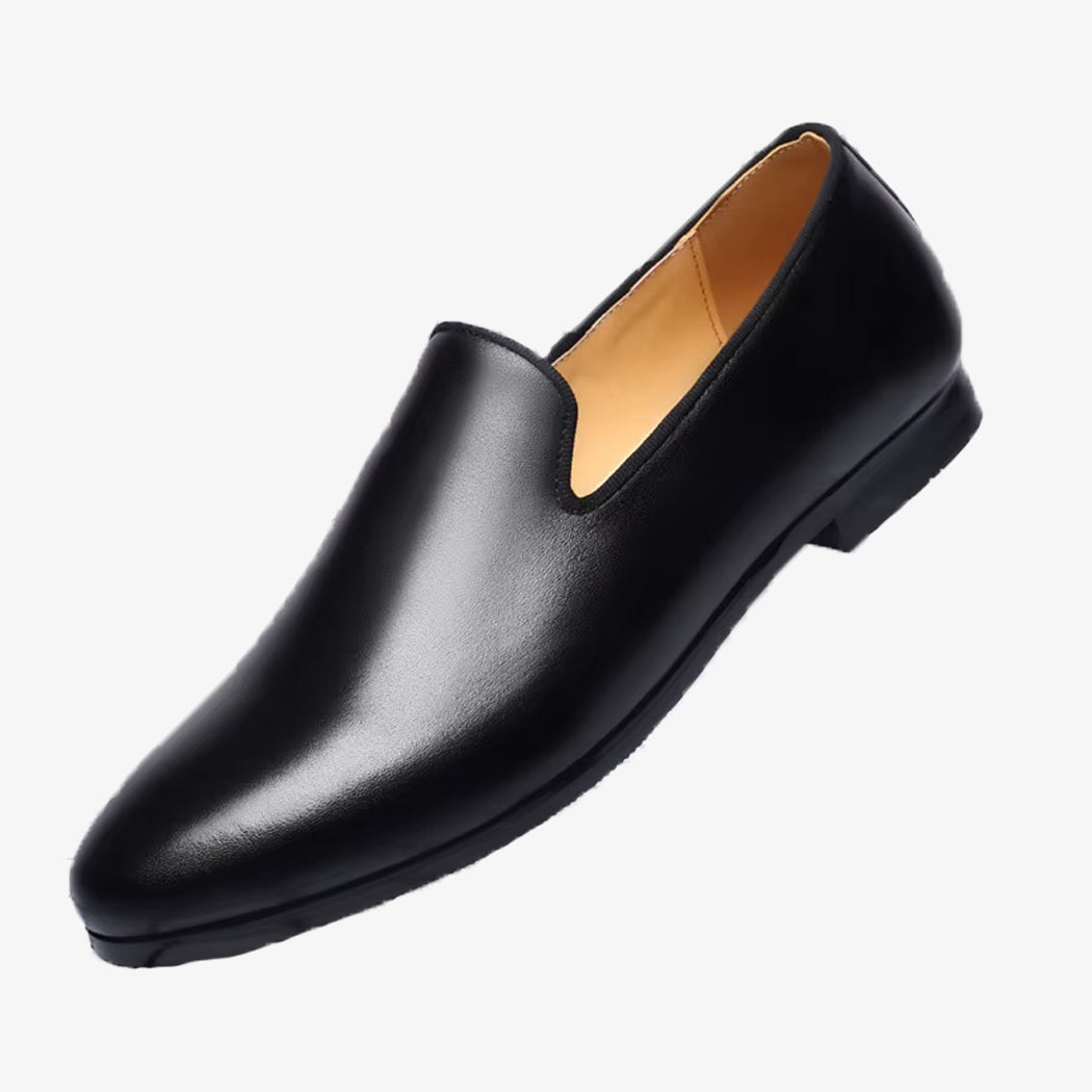Un mocasín minimalista para hombre de color negro sobre fondo blanco liso