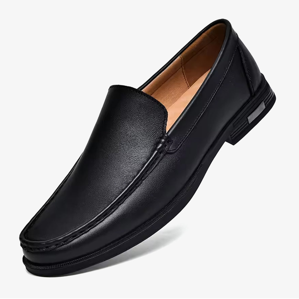 Un mocasín casual de cuero negro para hombre sobre un fondo blanco uniforme