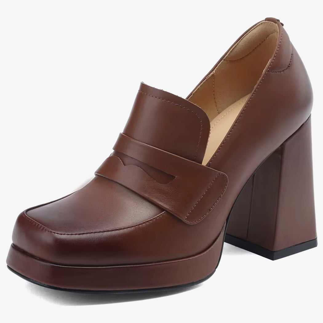 Un mocasín de tacón de piel para mujer de color marrón sobre un fondo blanco
