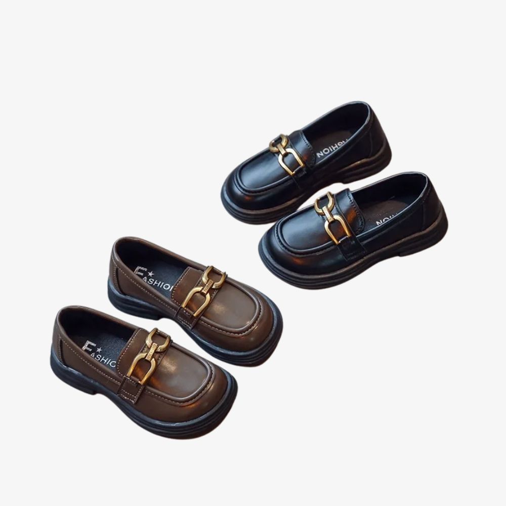 Dos pares de mocasines negros y marrones con hebillas, sobre fondo gris.