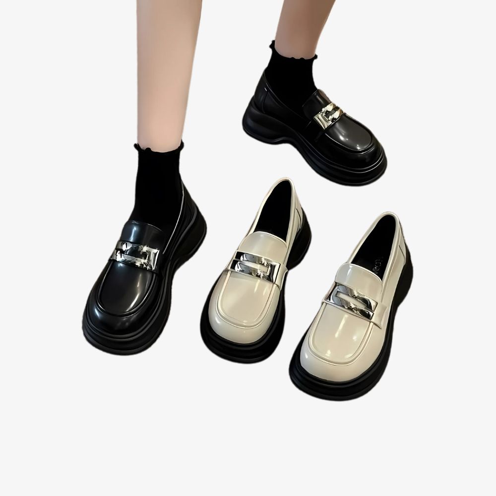 Piernas de mujer con mocasines negros de plataforma, junto a un par de los mismos zapatos en color beige