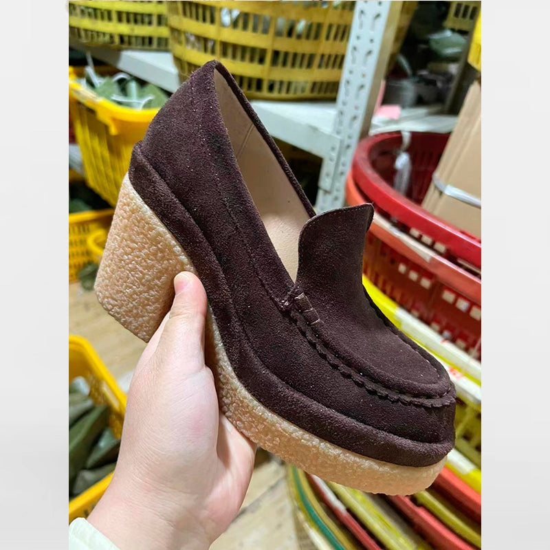mocasín de ante marrón con tacón para mujer cogido de la mano