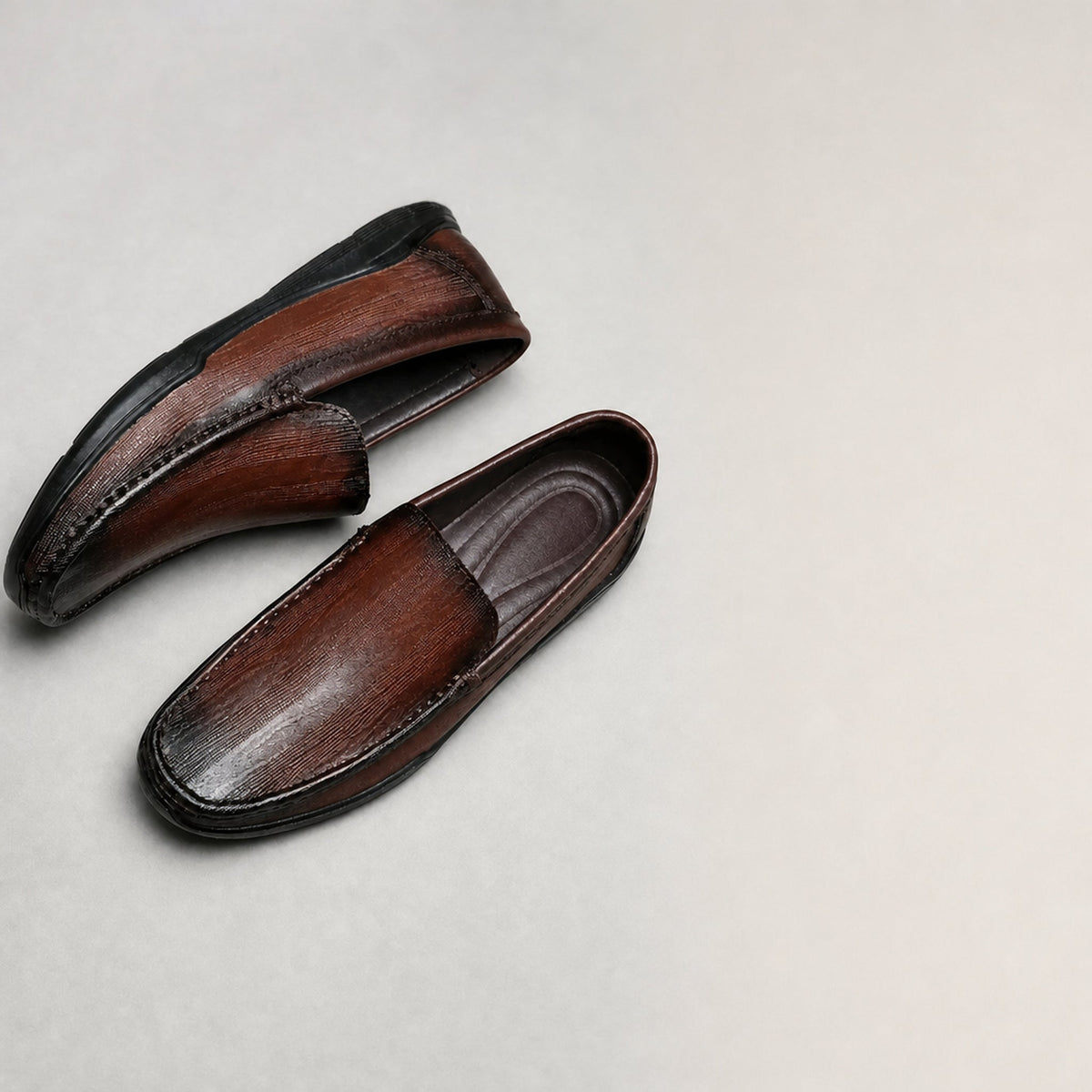 Mocasín clásico de hombre en piel lisa sin cordones, color marrón, detalle del material