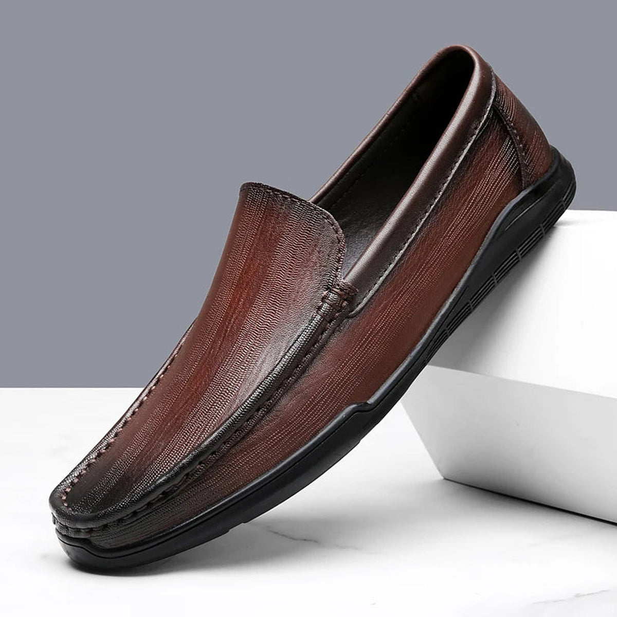 Mocasín clásico de hombre en piel lisa sin cordones, color marrón, detalle de la costura