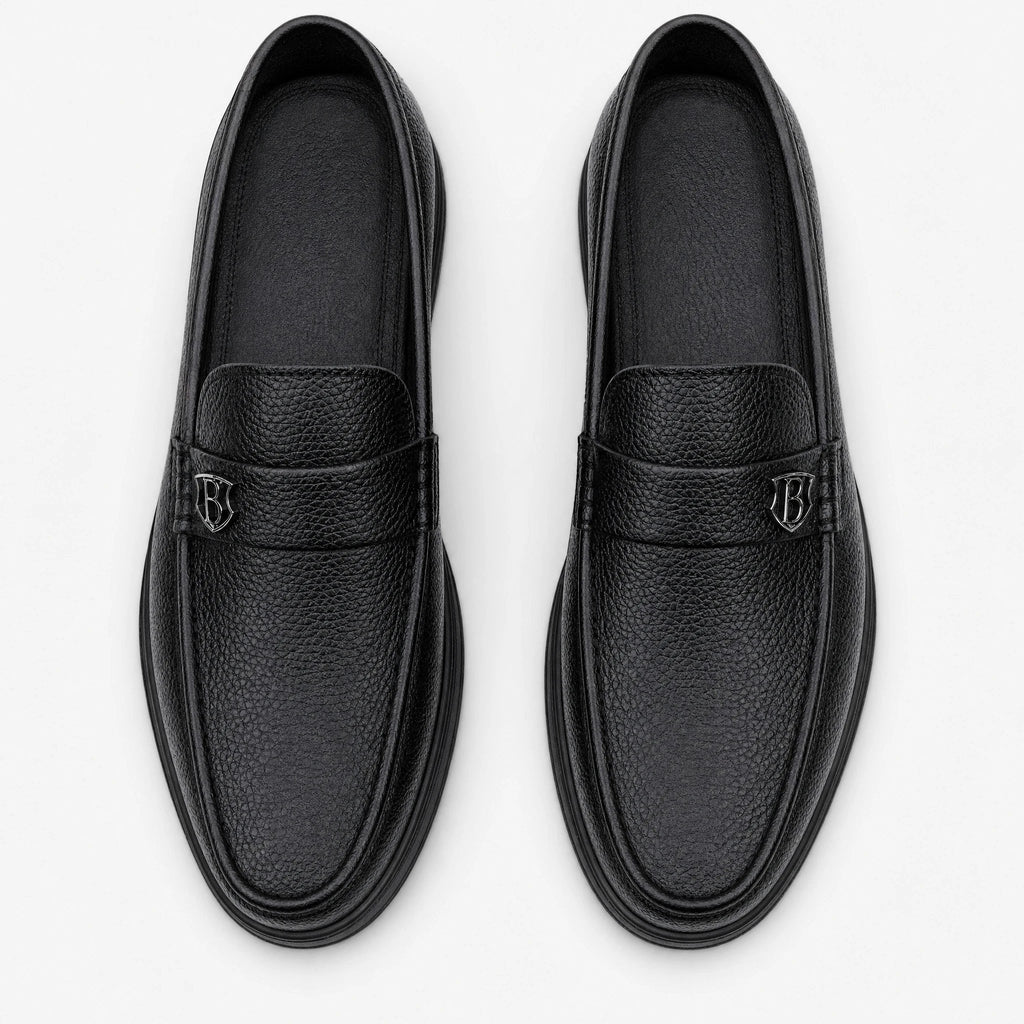 Mocasín de hombre negro de piel grabada con suela gruesa, vista lateral
