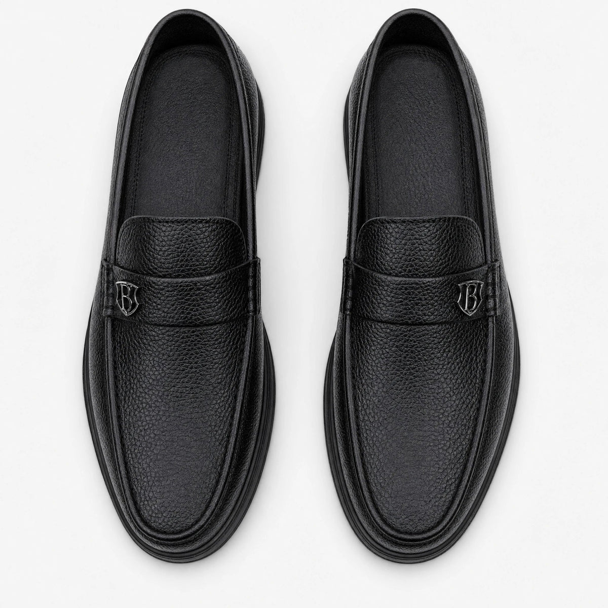 Mocasín de hombre negro de piel grabada con suela gruesa, vista lateral