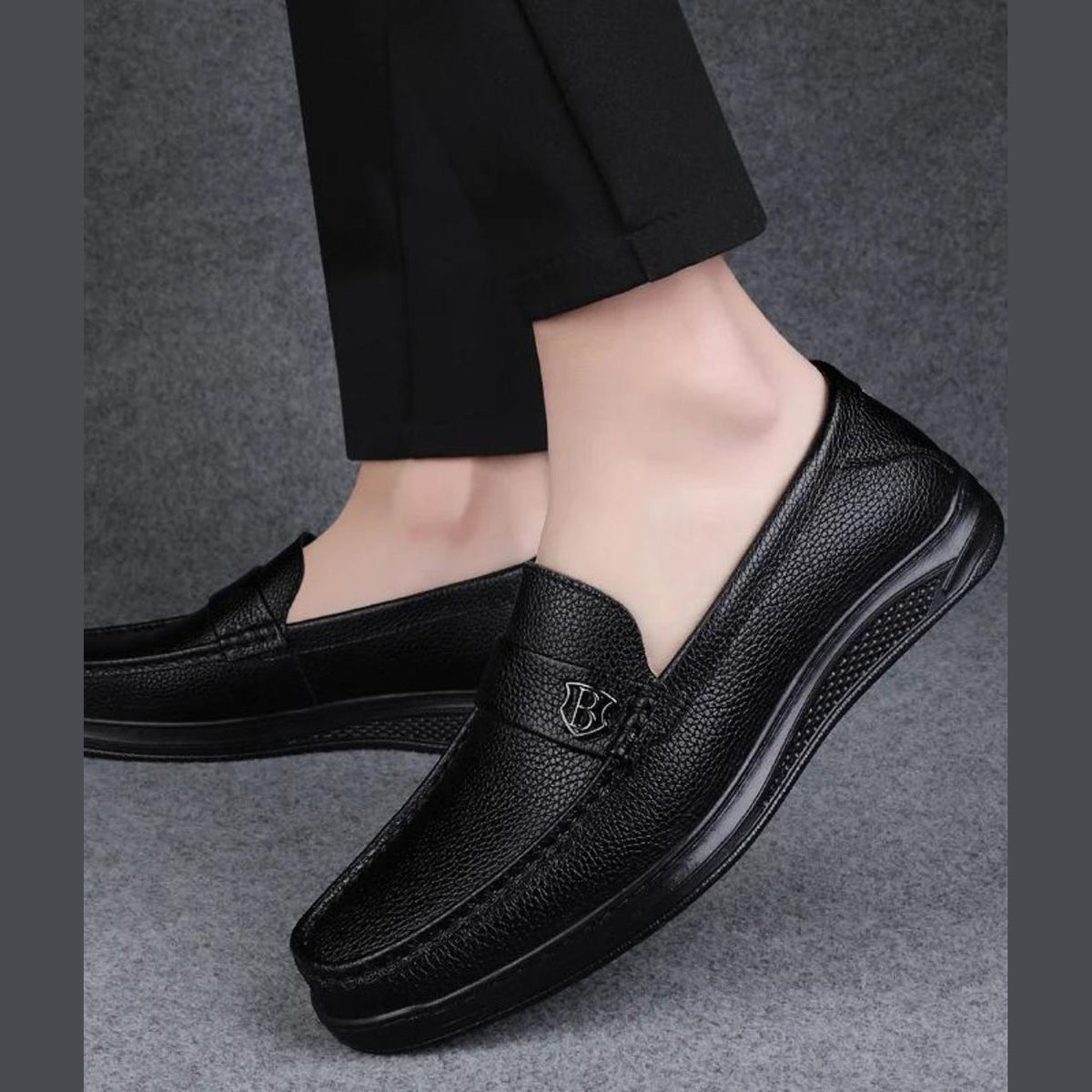 Mocasín de hombre negro de piel grabada con suela gruesa, detalle del material