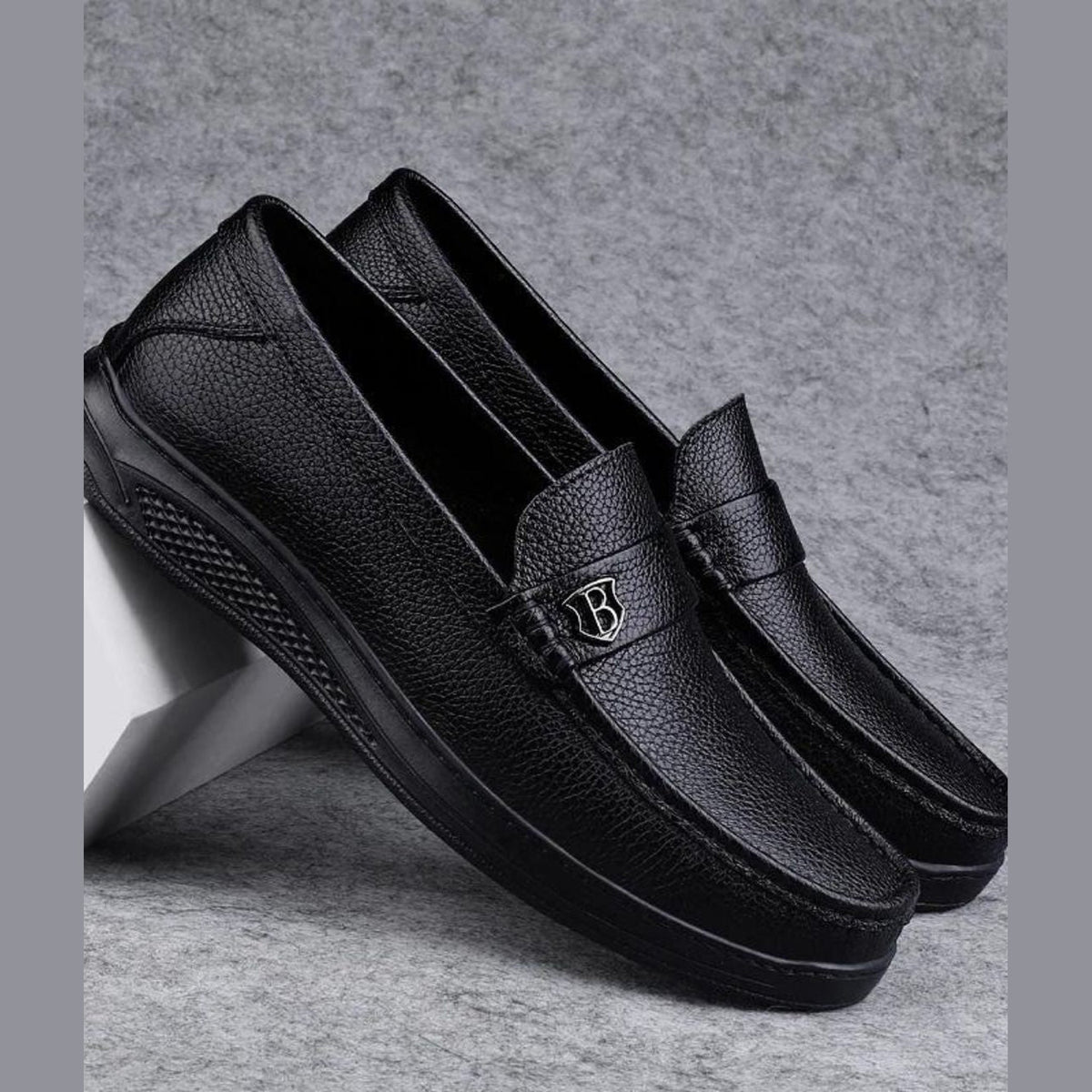 Mocasín de hombre negro de piel grabada con suela gruesa, detalle del acabado