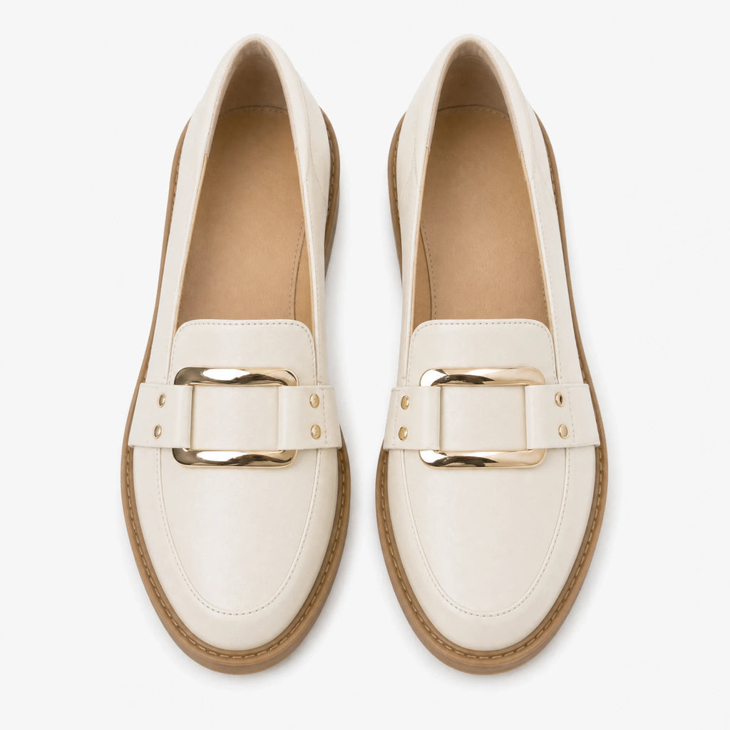 Mocasín de mujer beige con hebilla dorada y suela camel, vista lateral