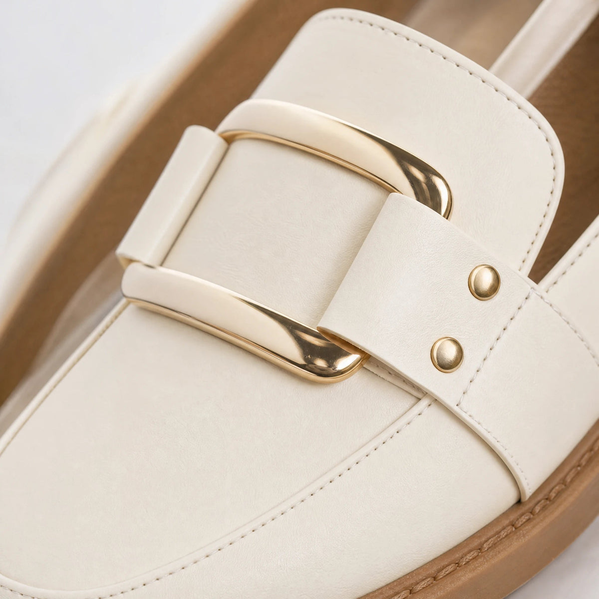 Mocasín de mujer beige con hebilla dorada y suela camel, vista frontal