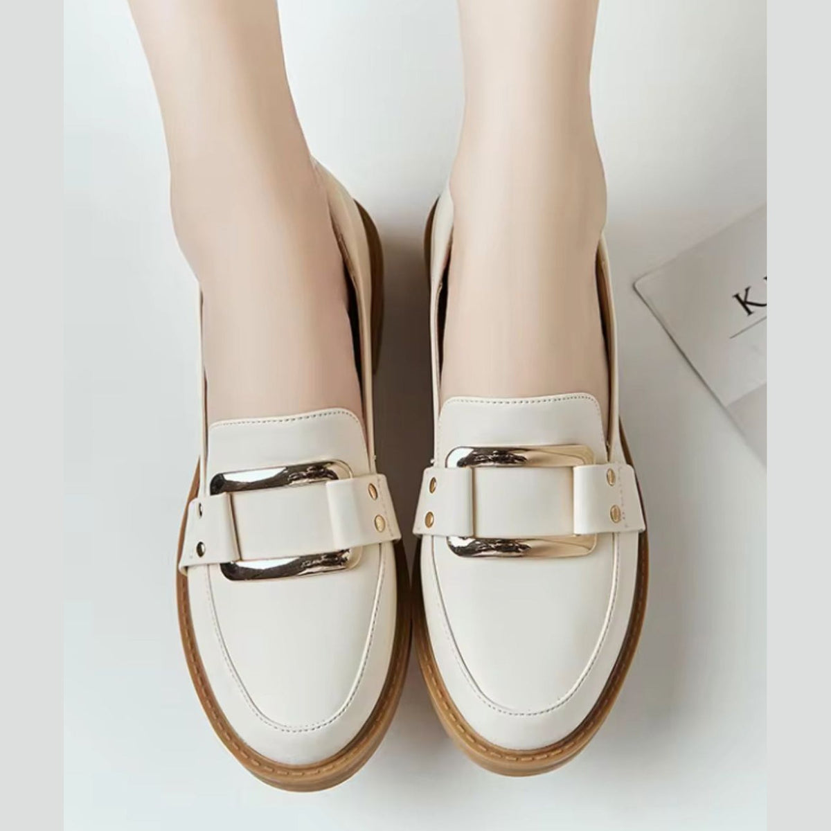 Mocasín de mujer beige con hebilla dorada y suela camel, par completo