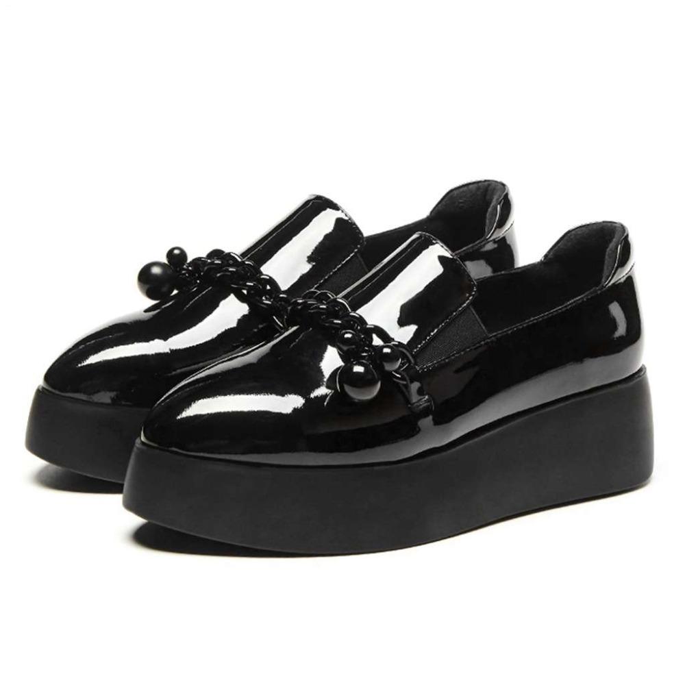 Mocasines negros brillantes de mujer con borlas pequeñas y suela ancha