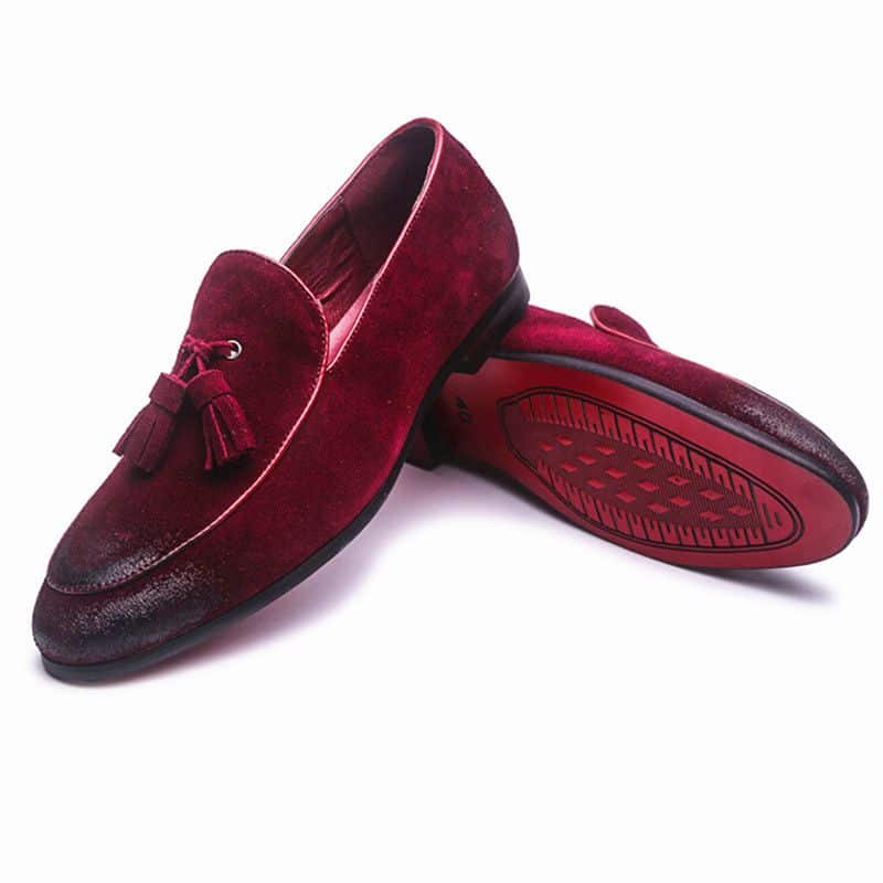 Mocasín rojo con borla sobre fondo blanco