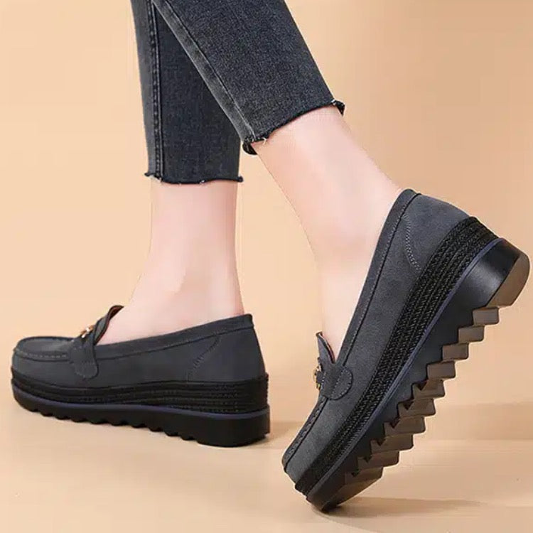 Mocasines con suela compensada y elementos decorativos metálicos para mujer