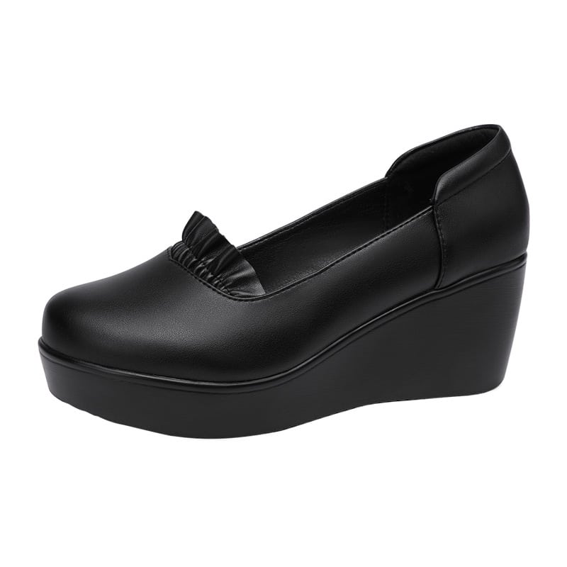 Foto de un mocasín de cuña negro sobre fondo blanco