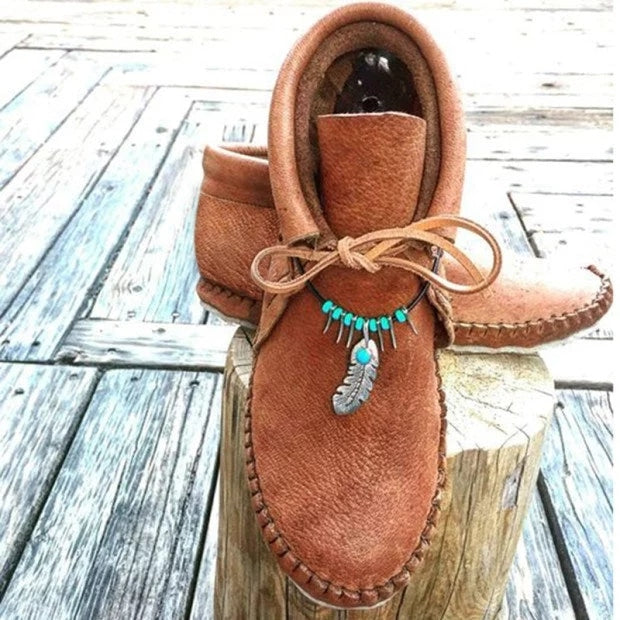Mocasines indios altos con plumas decorativas