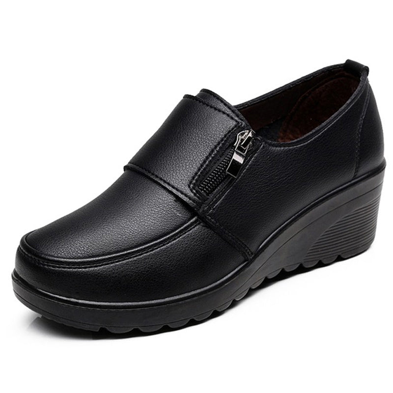 Mocasín negro de perfil con una pequeña cremallera lateral
