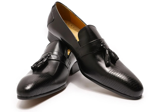 Mocasín negro brillante con borlas para mujer sobre fondo blanco