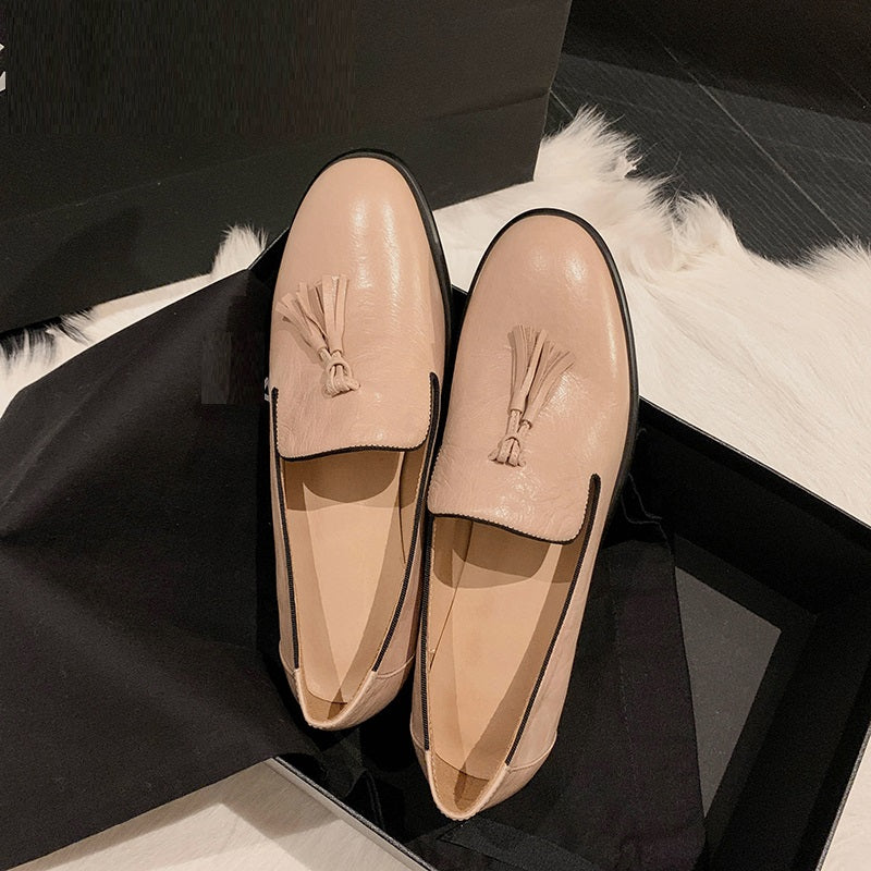 Par de mocasines de cuero rosa sobre un elemento negro