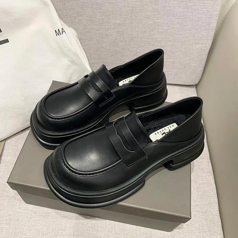 Dos mocasines negros sobre una caja