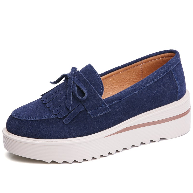 mocasín con borla de ante azul y suela blanca sobre fondo blanco