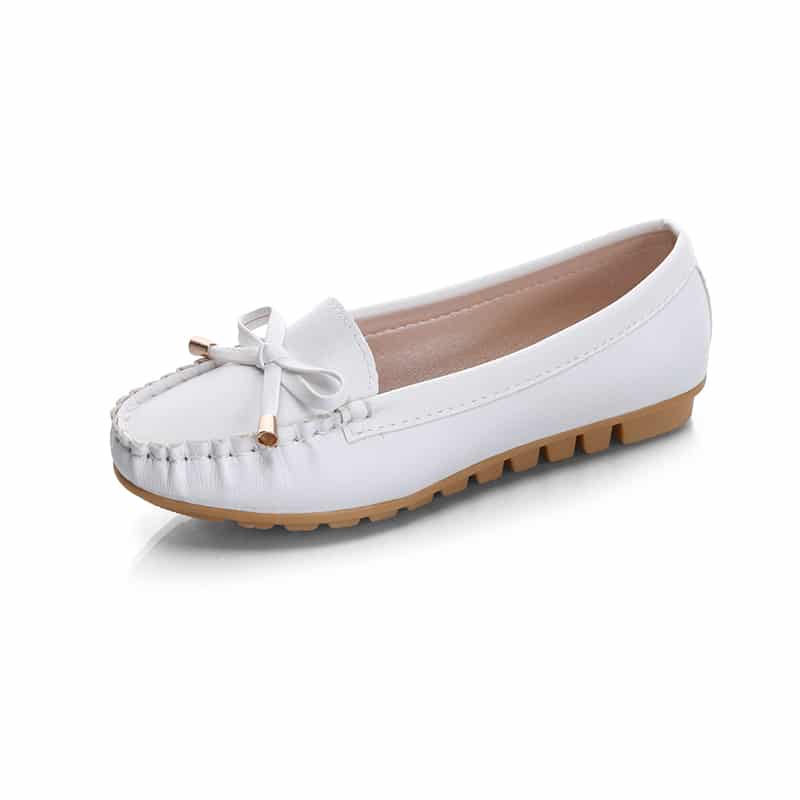 mocasín de piel sintética blanca con suela beige y borla sobre fondo blanco