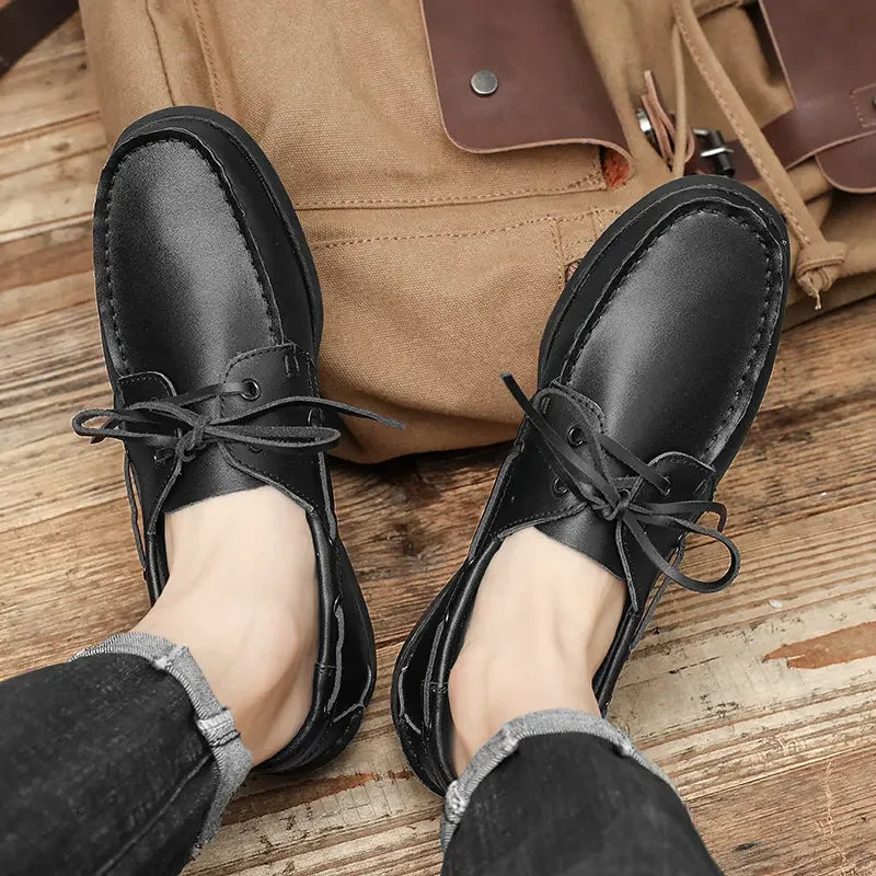 Zapato náutico de hombre negro con cordones en piel, puesto en el pie