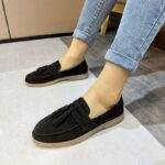 mocasín negro de ante con flecos llevado por una mujer