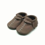mocasín bebé marrón de piel con costuras blancas visibles