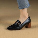 mocasín de cuero negro usado por una mujer