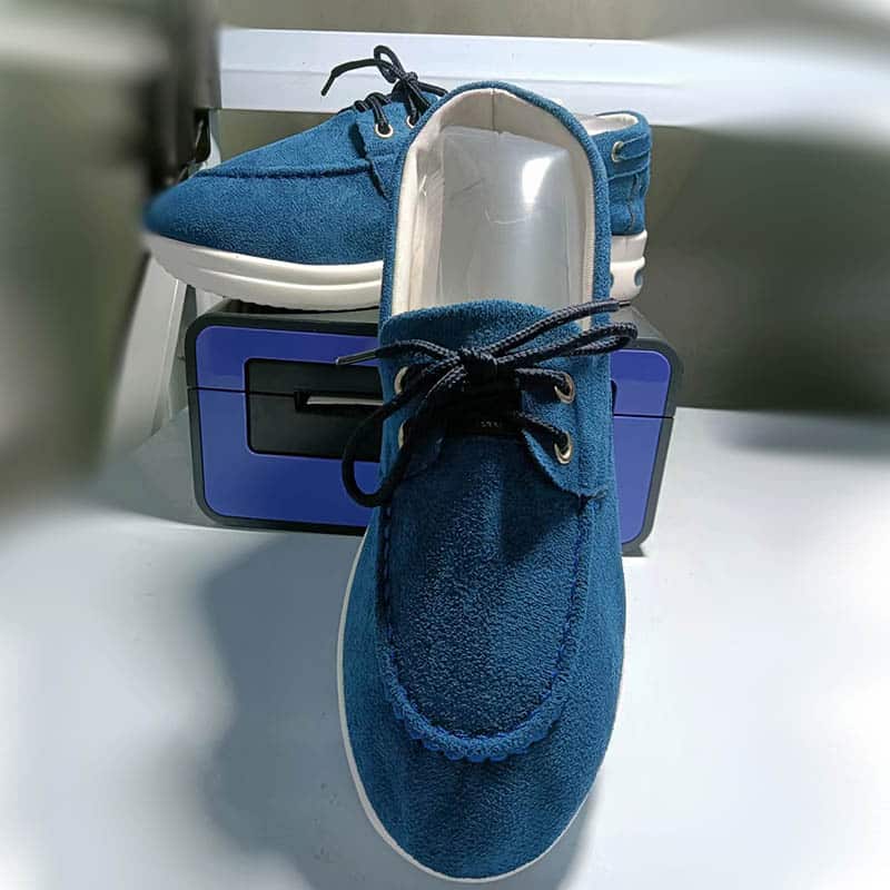 Foto de un par de mocasines de plataforma azules sobre un revestimiento blanco y colocados sobre un objeto azul