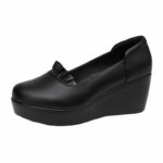 Foto de un mocasín de cuña negro sobre fondo blanco