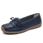 mocasín de cuero azul oscuro con borla en la parte superior sobre fondo blanco