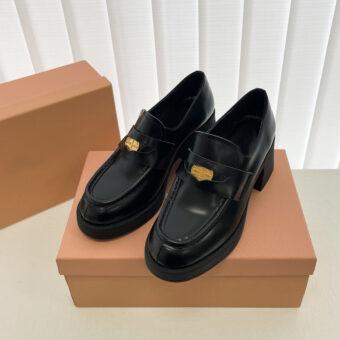 Mocasines negros en una caja de zapatos marrones