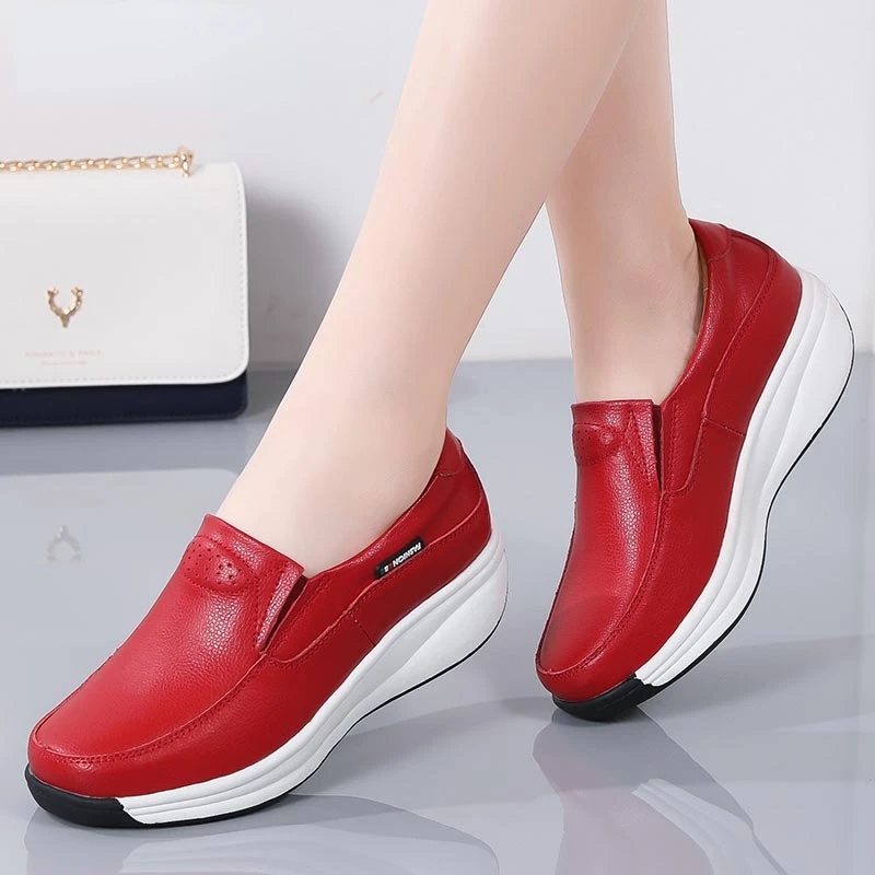 Par de pies en zapatos rojos con suela blanca