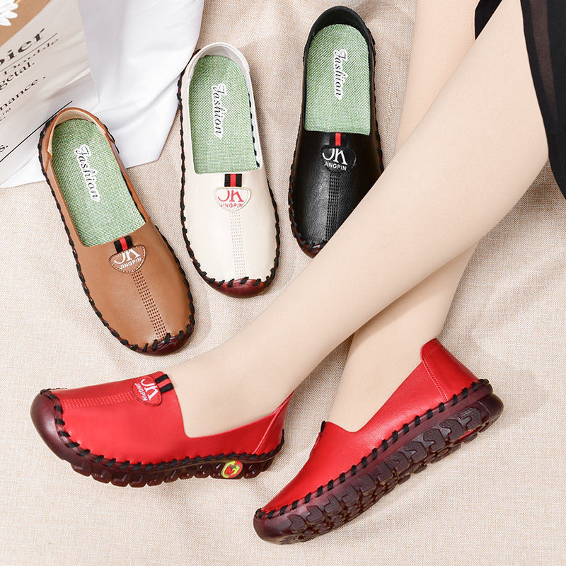 Piernas cruzadas con zapatos rojos en los pies junto a otros marrones, negros y blancos.