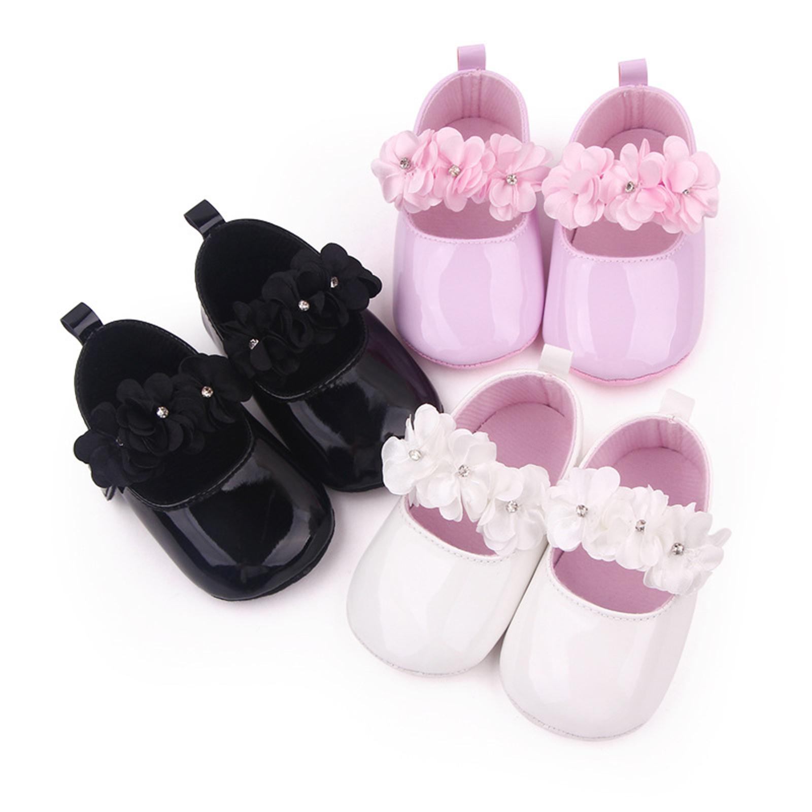 Tres pares de mocasines con flores sobre fondo blanco, en negro, rosa y blanco