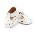 Par de mocasines blancos calados para bebé niña sobre fondo blanco