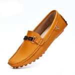 Mocasín camel con hebilla dorada de perfil sobre fondo blanco