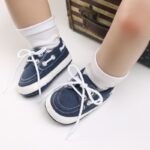 Piernas de bebé con calcetines blancos y mocasines azules estilo barco