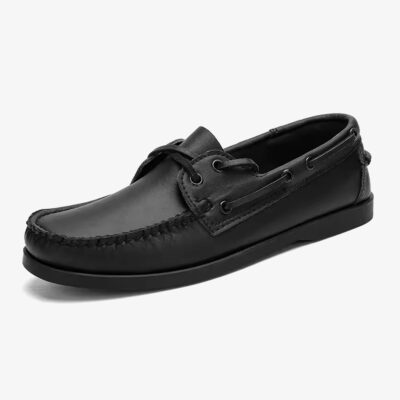 Un mocasín náutico de cuero negro para hombre sobre fondo blanco