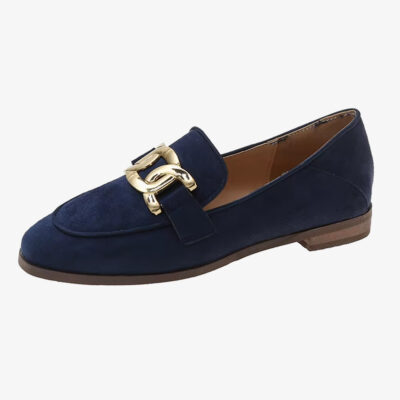 Un mocasín azul marino con hebilla de estilo vintage para mujer sobre fondo blanco