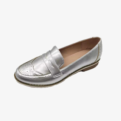 Un mocasín plateado chic para mujer sobre fondo blanco liso