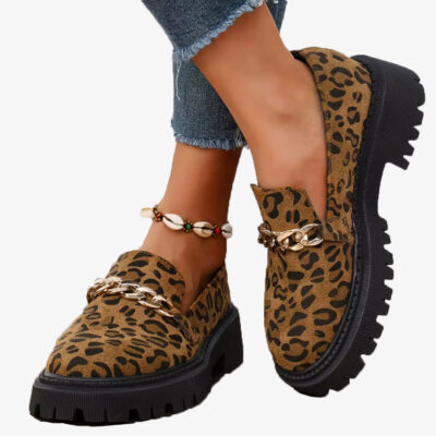 Par de mocasines de ante con estampado de leopardo y cadena, usados con vaqueros y tobillera de conchas